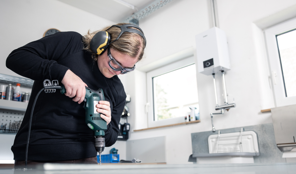 Junge Frau arbeitet in der Werkstatt.